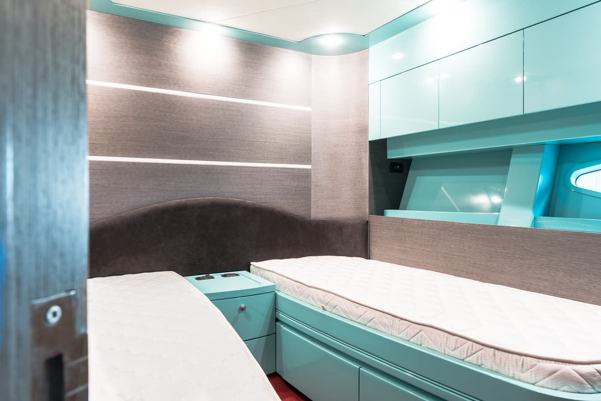 Cabina ospiti con oblò e mobili verde acqua
