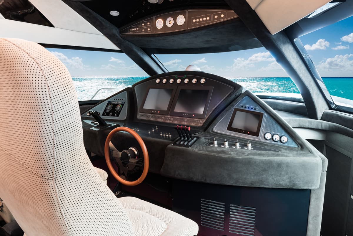 Postazione di guida con volante in legno e schermi